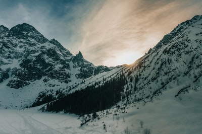 白天多云的天空下白雪覆盖的山
